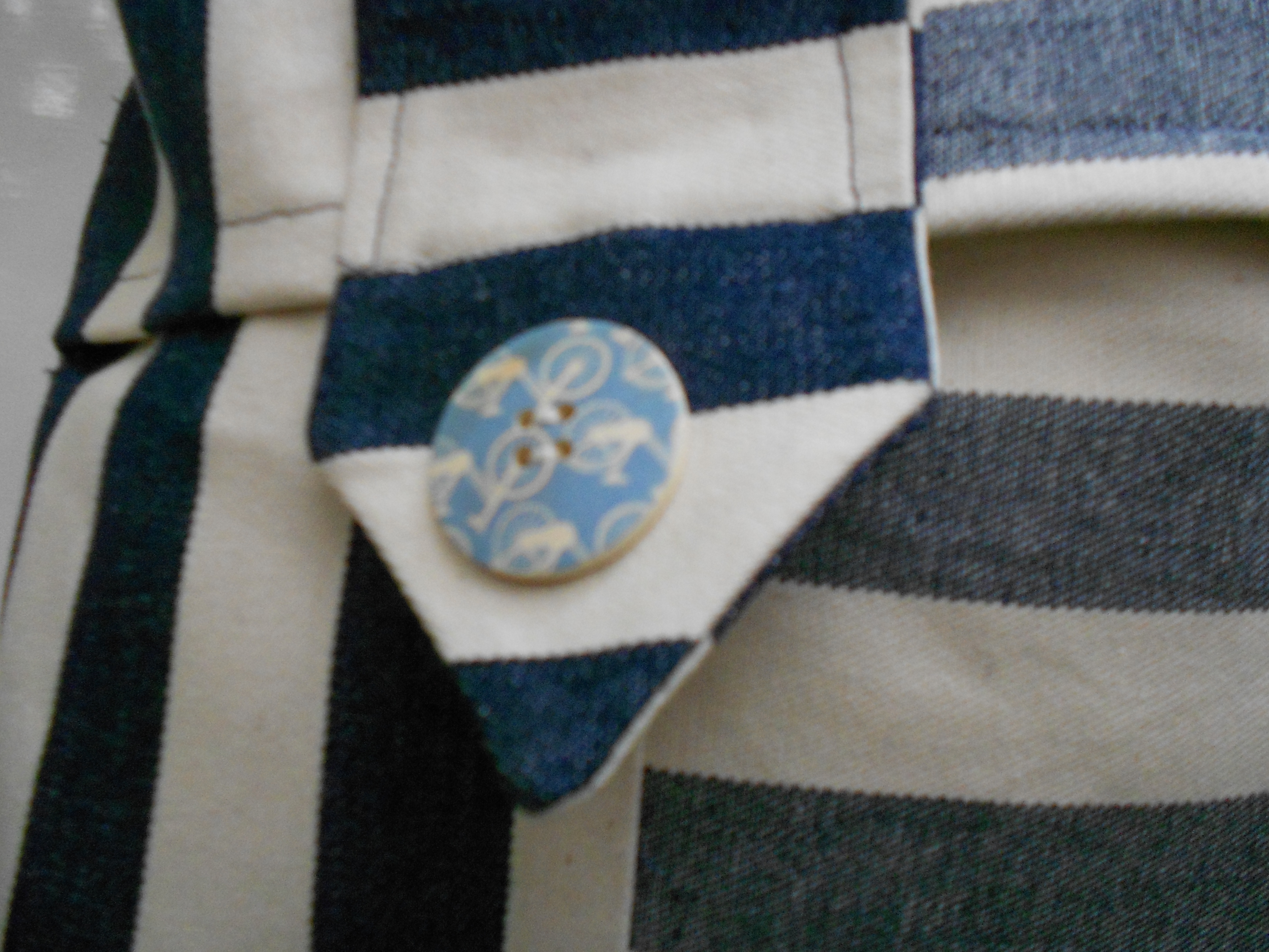 Cream And Blue Stripped Cushion Close Up of Tab And Pale Blue Button